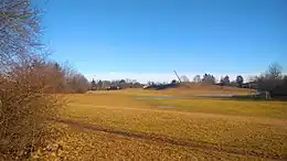 A field, with a hill and a sculpture in Årstaparken