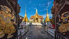 A Thai temple complex with several ornate buildings, and a lot of visitors