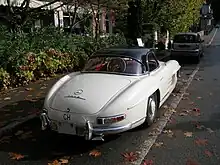 A hard-top roadster parked on a street