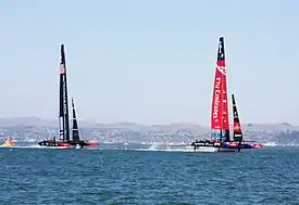 Color photograph of a racing catamaran underway with the starboard hull out of the water