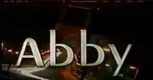 An image with the word "Abby" against a dark backdrop with lights