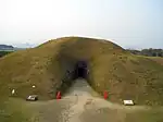 Grass covered hillock with an entrance.