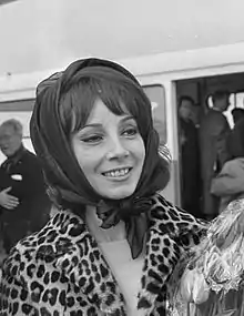 Black-and-white photo of a young woman smiling in a head scarf.