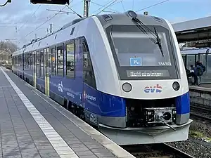 White rail vehicle with blue striping at station platform