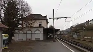 Two-story building with railroad tracks to the right