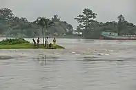 People on an island in a flooded river in Bangladesh