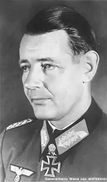 Black-and-white portrait of a man in semi profile wearing a military uniform with an Iron Cross displayed at his neck.