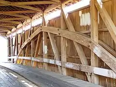 Interior structure of a covered bridge utilizing a kingpost with a Burr Arch structure