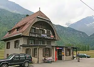 Three-story stone building with half-hip roof