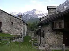 Two stone houses, with mountain in background