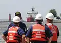 Coast Guardsmen await the arrival of the USCGC Mackinaw