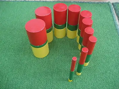 The green, yellow, and red cylinders are stacked on top of each other.