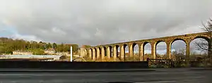 A curving viaduct bathed in sunshine, traversing a low valley