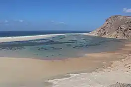 A sandy beach framed by rocky cliffs