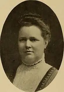 A white woman in an oval frame; her hair is arranged in an updo; she is wearing a dress or blouse with a high lace collar and bib.