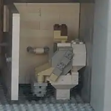 A Lego man using the toilet at Grand Central Station