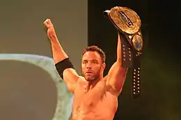 Eli Drake with the fourth title belt design; note the "Impact" plate added to the title belt to reflect the company reverting to the Impact Wrestling name.