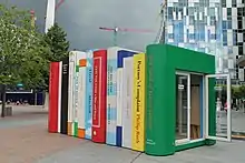 Shipping container decorated to look like a row of giant books from the outside.