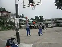 Schoolgirls shooting hoops among the Himalayas in Dharamsala, India.