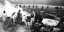 Explosive ordnance disposal personnel work to recover the buried thermonuclear bomb that fell into a field in Faro