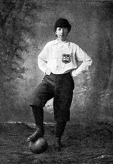 Black and white photo of Matthew wearing a white top with a football under her foot