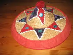 A decorative Assamese jaapi constructed with bamboo while the decorations are felt, threads and tin glitter