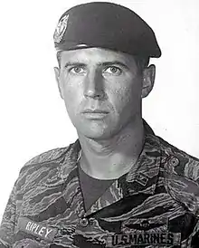 Portrait of a Marine. He is wearing a black beret and tiger stripe camouflage. His name tape says Ripley.