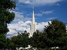 Looking at a spire of a church coming up out of the trees