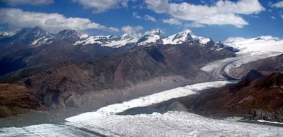 2007: The loss of thickness (about 200 m (660 ft)) of the lower Gorner Glacier since its major expansion in 1859 is easily recognizable on the south flank of the Gornergrat by the left over and much higher situated lateral moraine (see the light-coloured part above the grey flank; as seen from Klein Matterhorn)