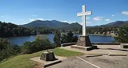 A Christian cross stands above the community.