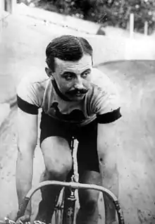 A man on a bicycle, riding on an outdoor velodrome.