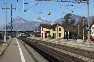 Double tracks, platforms, and a yellow two-story building