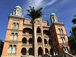 Ornate three-story building, with a palm tree in front