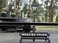 Station platform with "Menzies Creek" bench