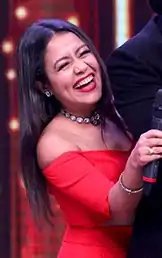 Neha Kakkar laughing while hugging Shah Rukh Khan