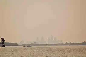 View across a lake to a silhoutted skyline of a major city