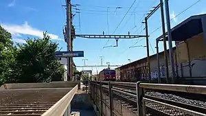 Red train passing side platform