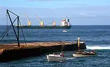 Kingston Pier, with launch towing a lighter with cargo from ship moored off-shore