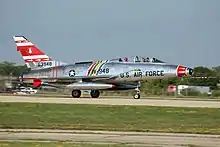 A North American F-100F single-engined two-seat jet fighter on runway.