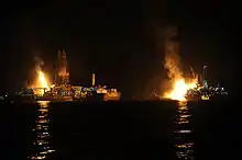 Q4000 and Discoverer Enterprise flare off gas at the site of drilling operations at the Deepwater Horizon response site in the Gulf of Mexico at night 8 July 2010.