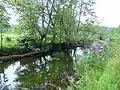 The stone abutments of a former bridge, one on each bank, downstream from Bankfoot.