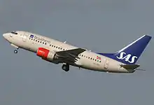 A medium-sized twin-engined jetliner with red engines and a blue tail