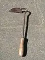 A hand hoe, i.e. a small, short-handled hoe