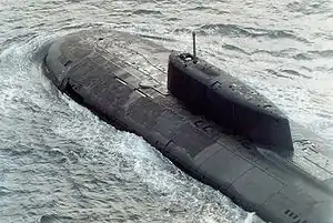 This picture clearly displays the arrangement of the hatches in the hull above the missile tubes, on either side of the dorsal fin. Also shown is the opening for the forward hydroplane (currently folded in), as well as the bulge on the top of the fin under which the rescue capsule is located. Although partially obscured by shadow, the seam between the capsule and the fin is faintly visible.