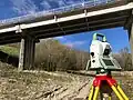 Total station facing a bridge pile for survey