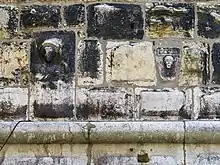 Reliefs of bust of Saint and human face with flower and date MCCLII (A.D. 1253) on the northern facade of the  tower.