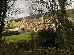 Large house seen through trees.