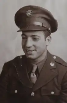 A photograph of Trause taken during World War II, with Trause wearing a coat, shirt, tie, and U.S. army-issued hat