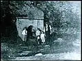 Older photo of family getting water from the spring