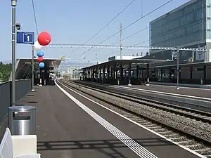 Double-tracked railway line with canopy-covered platforms